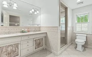 a bathroom with a granite countertop sink a toilet and a mirror