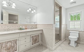 60 Washington Street, Unit 60 Sherborn, MA 01770 - Photo 9 of 15 a bathroom with a granite countertop sink a toilet and a mirror