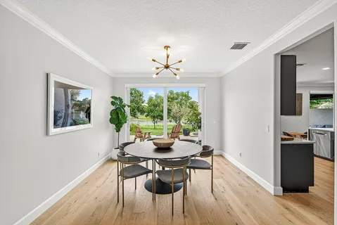 a dining room with furniture a large window and wooden floor