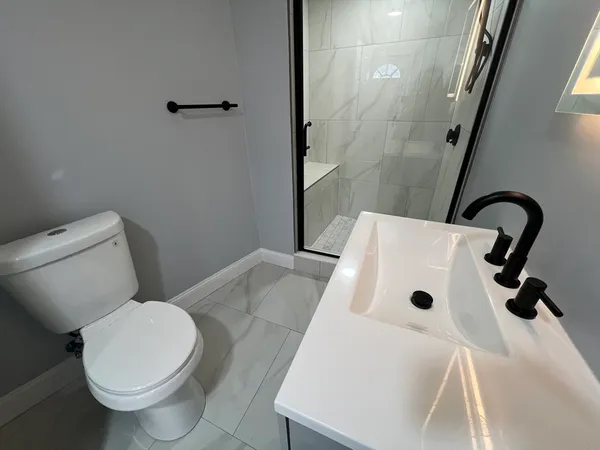 a bathroom with a sink a toilet and shower