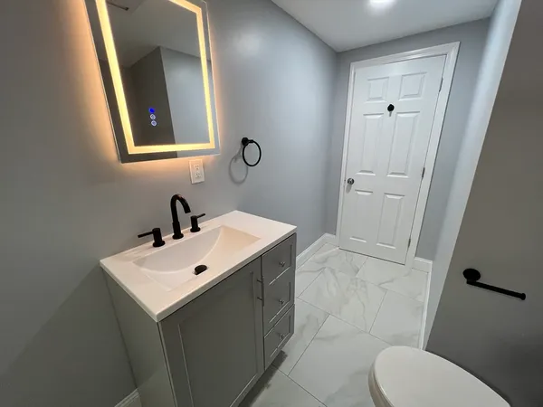 a bathroom with a toilet sink and mirror