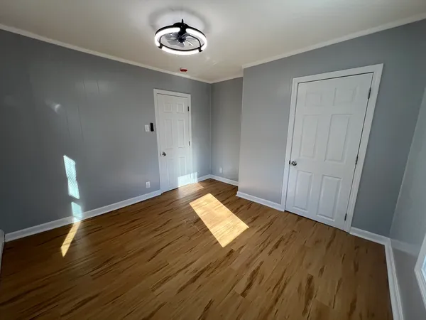 a view of empty room with wooden floor