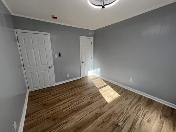 a view of empty room with wooden floor
