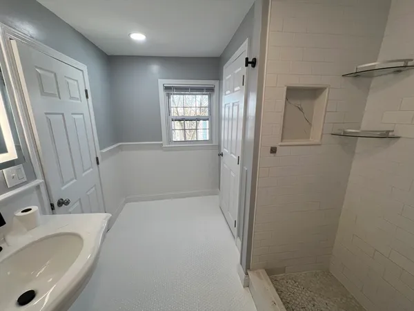 a bathroom with a tub sink and mirror