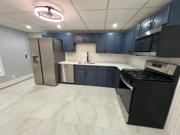 a large kitchen with stainless steel appliances granite countertop a stove a sink dishwasher and a refrigerator