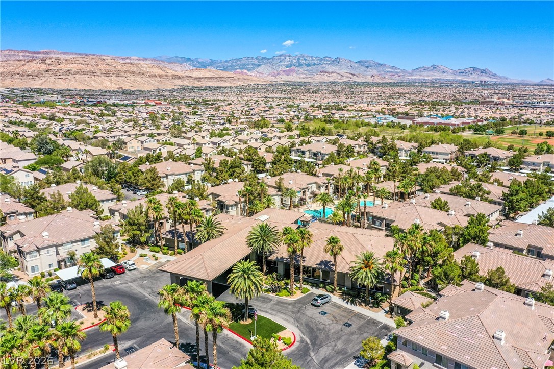 9050 West Warm Springs Road, Unit 1011 Las Vegas, NV 89148 - Photo 30 of 32 An aerial panorama reveals a vibrant community with pools, palms, and mountainous backdrops.