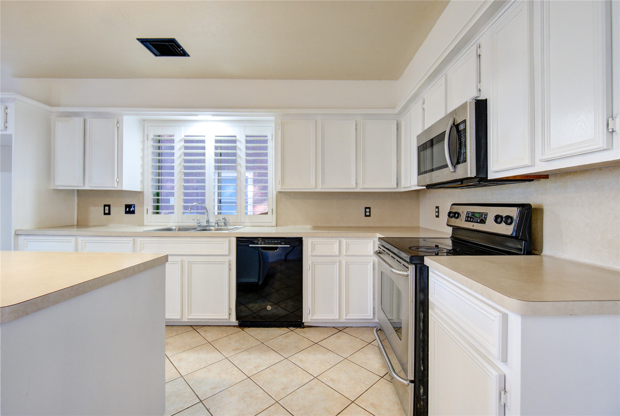 5931 Thom Road Humble, TX 77346 - Photo 5 of 18 a kitchen with stainless steel appliances granite countertop a stove a sink and a microwave