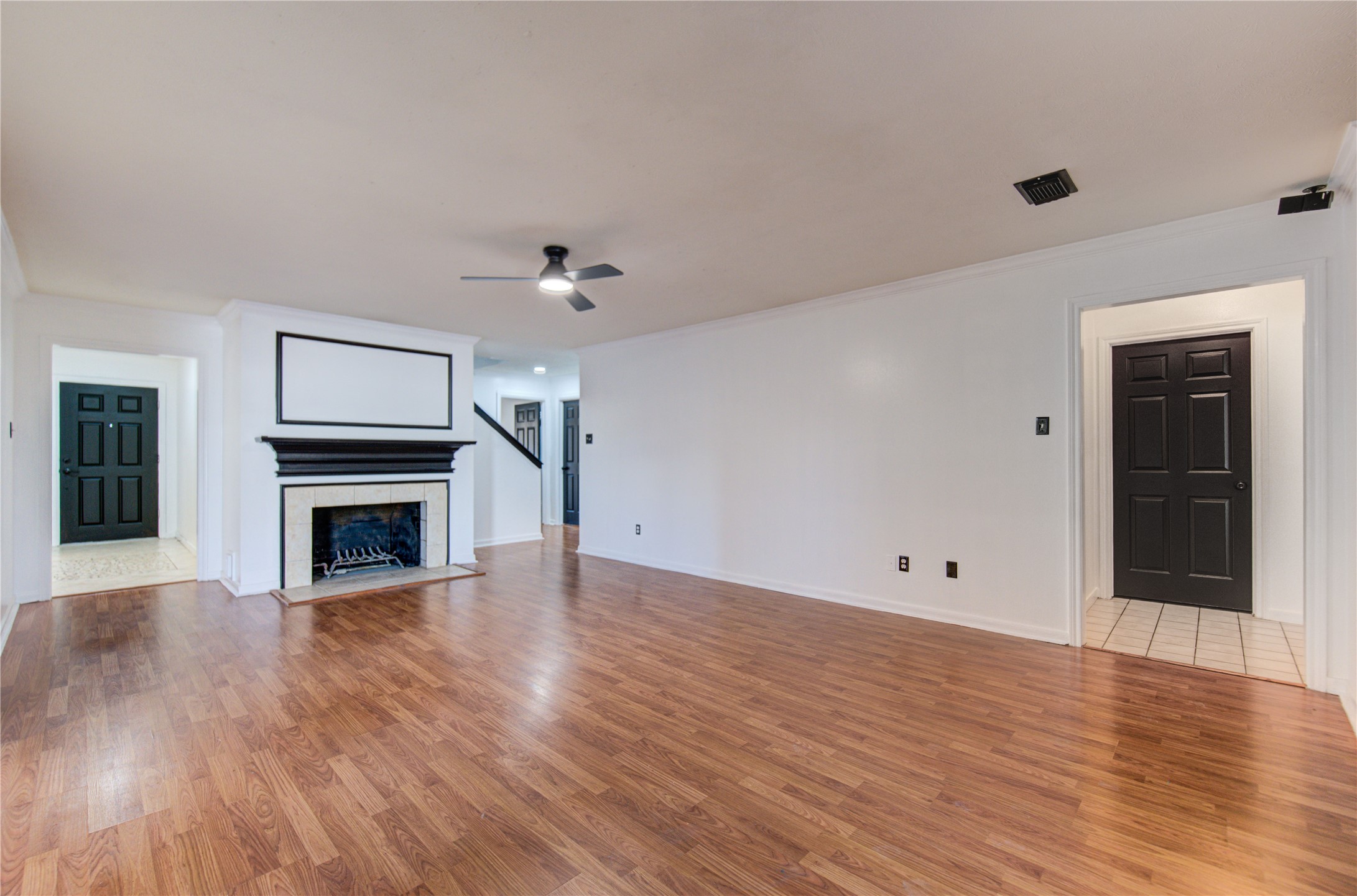 5931 Thom Road Humble, TX 77346 - Photo 7 of 18 an empty room with wooden floor fireplace and windows