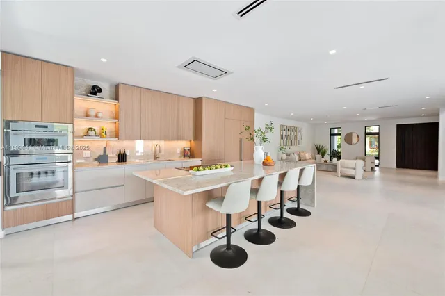 a kitchen that has a lot of white cabinets and stainless steel appliances