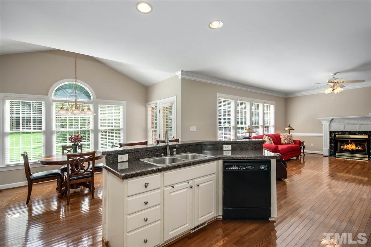 3920 Lauriston Road Raleigh, NC 27616 - Photo 9 of 27 a kitchen with stainless steel appliances granite countertop a stove a sink a dining table and chairs with wooden floor