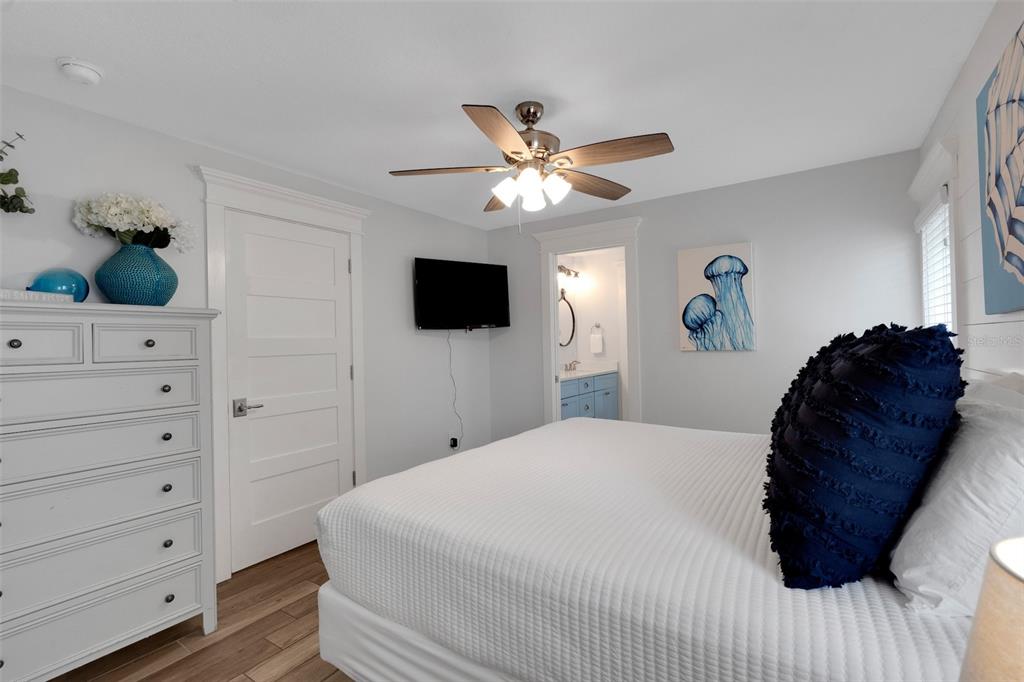 538 Canal Road Sarasota, FL 34242 - Photo 12 of 49 a bedroom with a bed a dresser and a potted plant