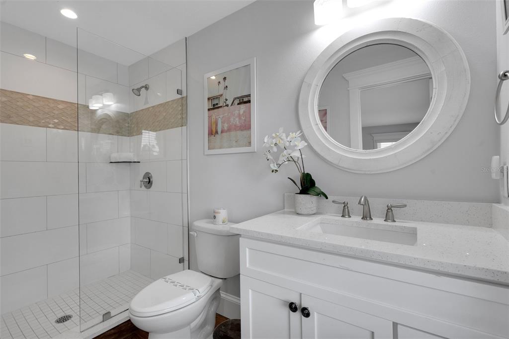 538 Canal Road Sarasota, FL 34242 - Photo 16 of 49 a bathroom with a toilet a sink a mirror and shower