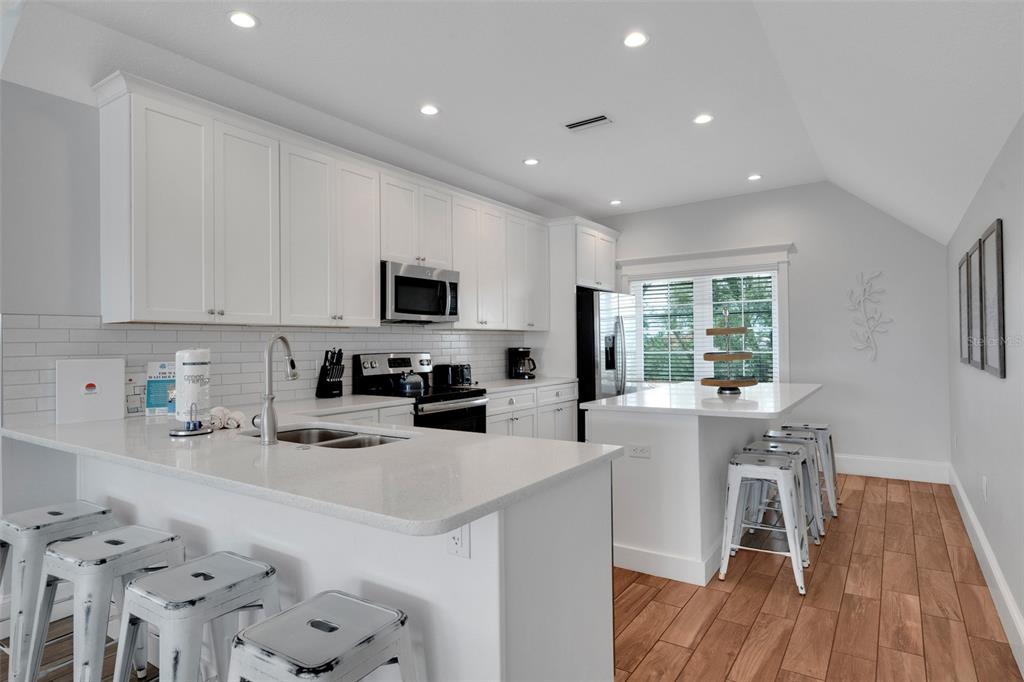 538 Canal Road Sarasota, FL 34242 - Photo 34 of 49 a kitchen with white cabinets and stainless steel appliances