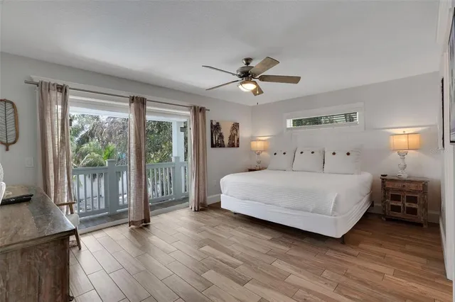 a spacious bedroom with a bed a ceiling fan and a large window
