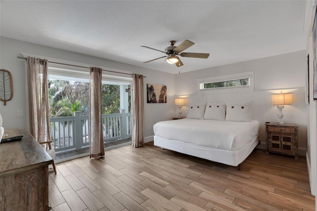 538 Canal Road Sarasota, FL 34242 - Photo 40 of 49 a spacious bedroom with a bed a ceiling fan and a large window