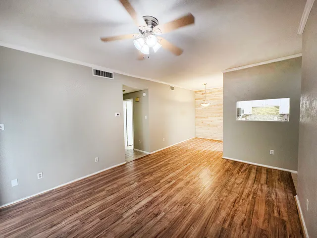 a view of empty room with wooden floor
