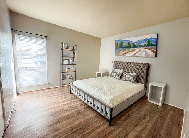 a bedroom with a bed and a large window