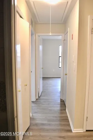 a view of a hallway with wooden floor