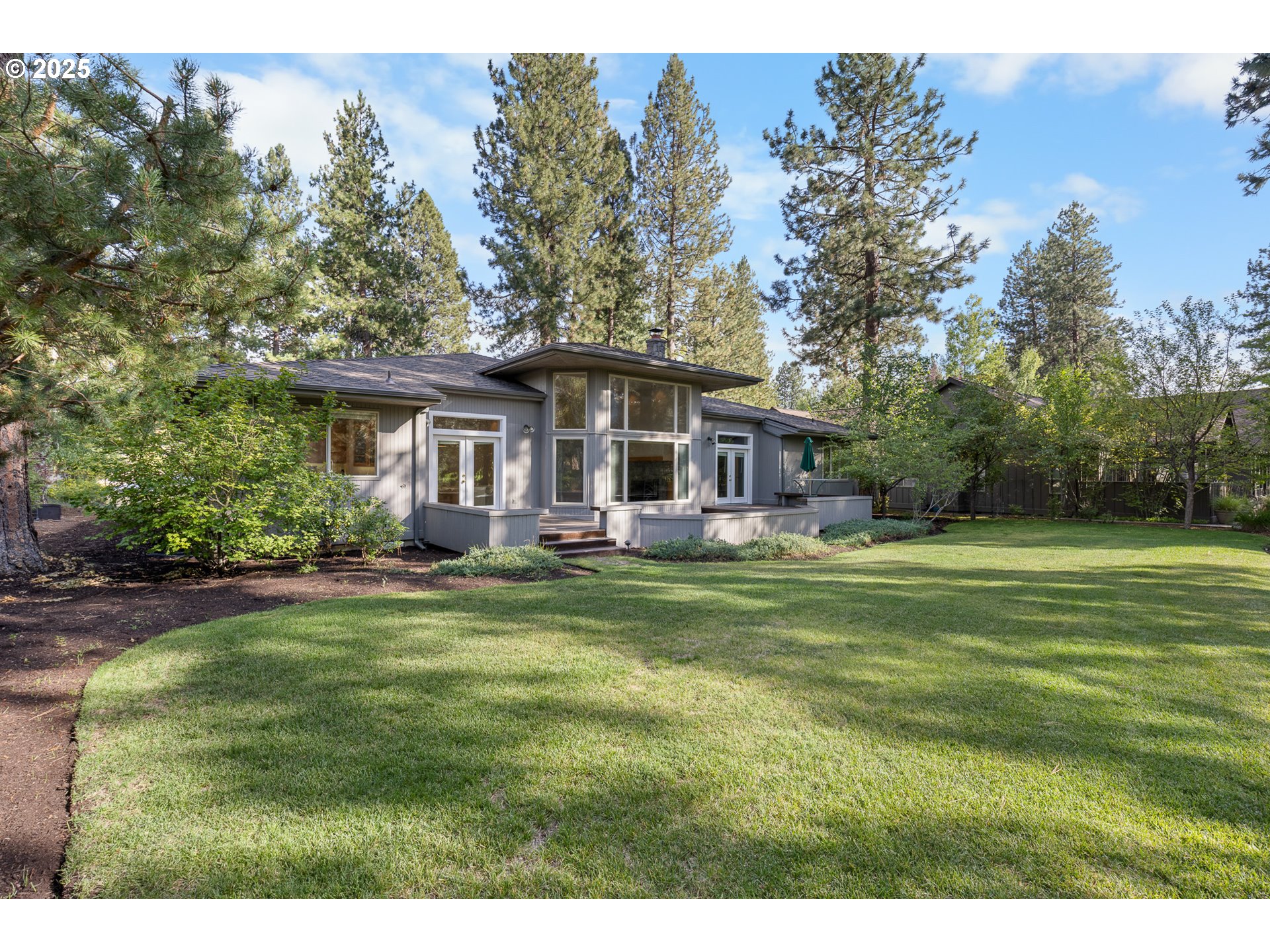 60799 Currant Way Bend, OR 97702 - Photo 23 of 28 a front view of a house with a garden