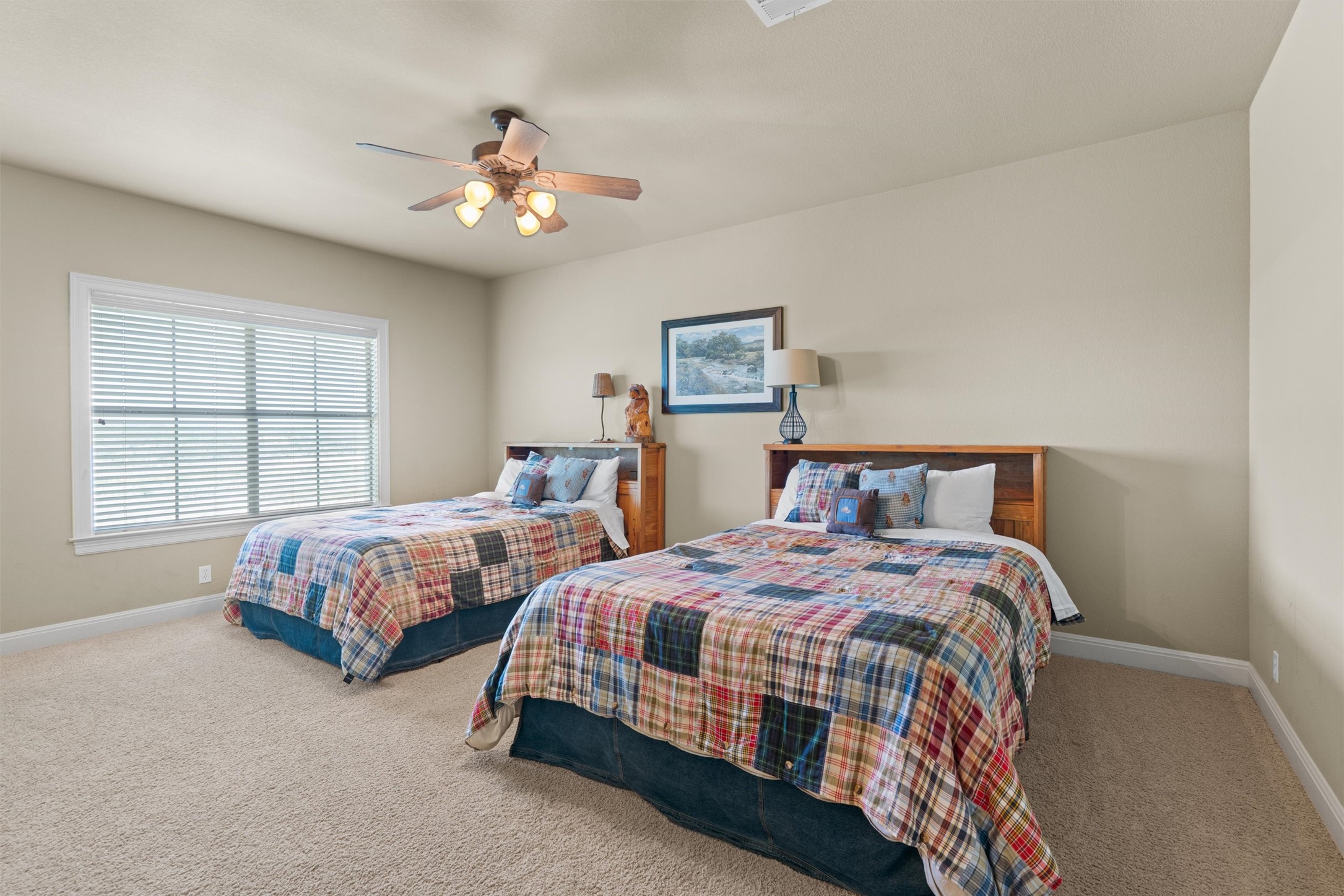 1017 Coventry Road Spicewood, TX 78669 - Photo 31 of 43 a bedroom with two beds and a chandelier