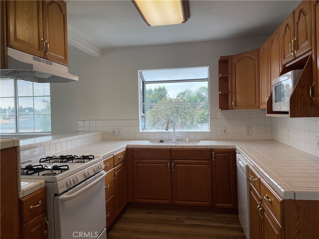 4891 Grace Avenue Cypress, CA 90630 - Photo 10 of 14 a kitchen with a sink stove top oven and cabinets