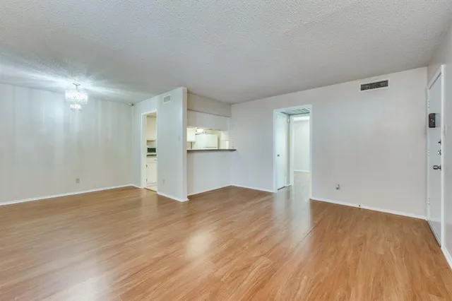 a view of a kitchen with wooden floor and a window