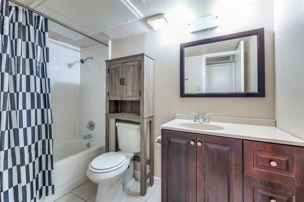12830 Midway Road, Unit 1120 Dallas, TX 75244 - Photo 11 of 14 a bathroom with a toilet sink and mirror