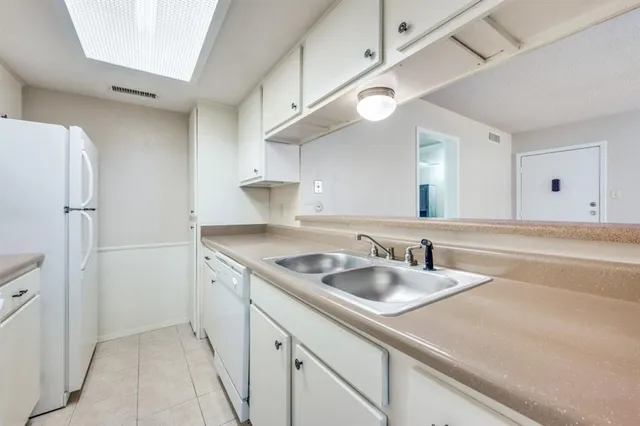 a kitchen with white cabinets and white appliances
