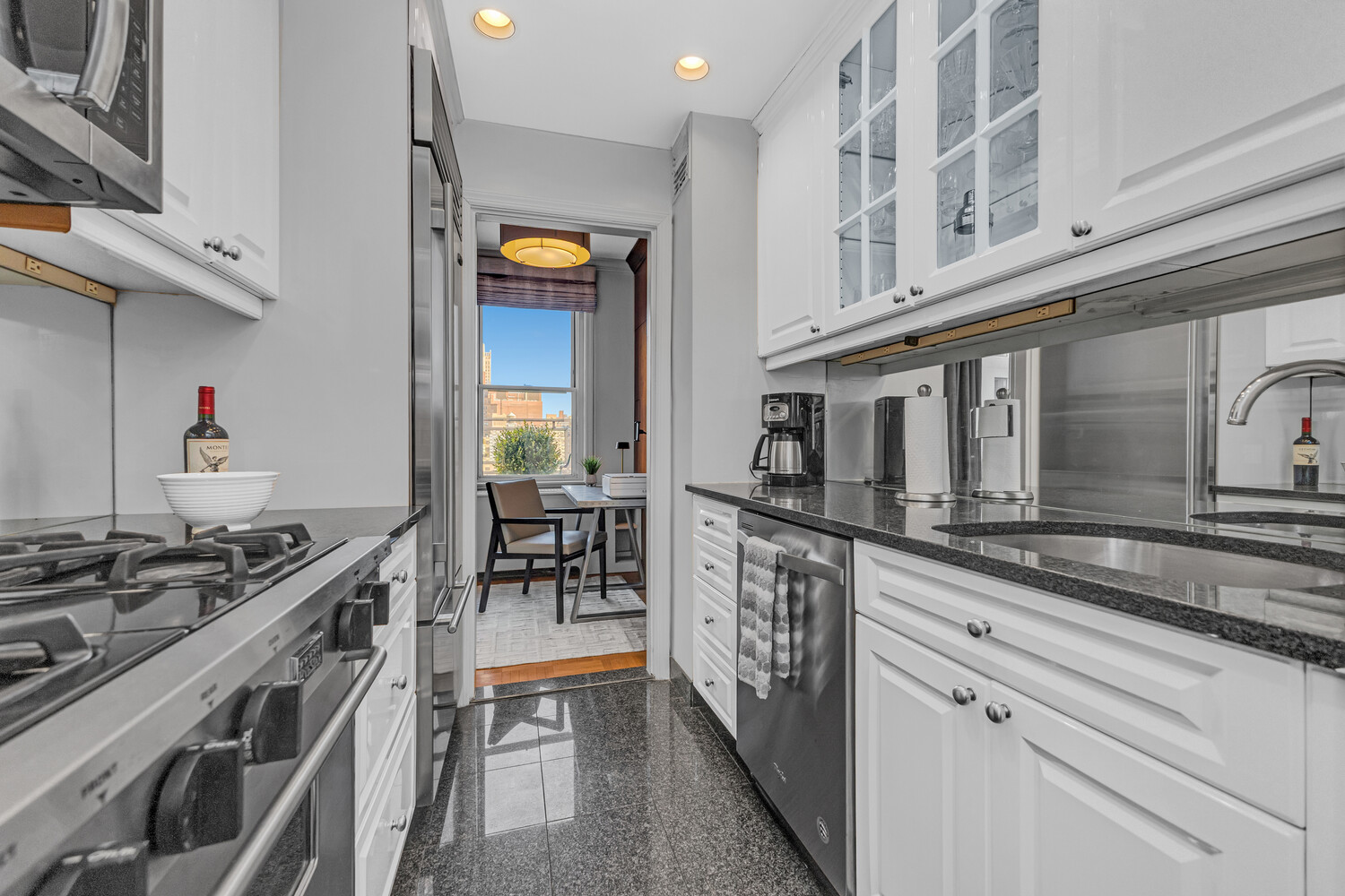 207 East 74th Street, Unit PHG Manhattan, NY 10021 - Photo 8 of 12 a kitchen with stainless steel appliances granite countertop a stove and a sink