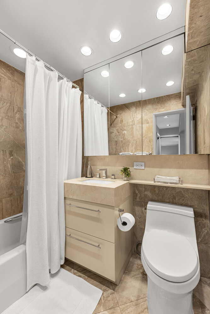 207 East 74th Street, Unit PHG Manhattan, NY 10021 - Photo 9 of 12 a bathroom with a sink a toilet and a bathtub