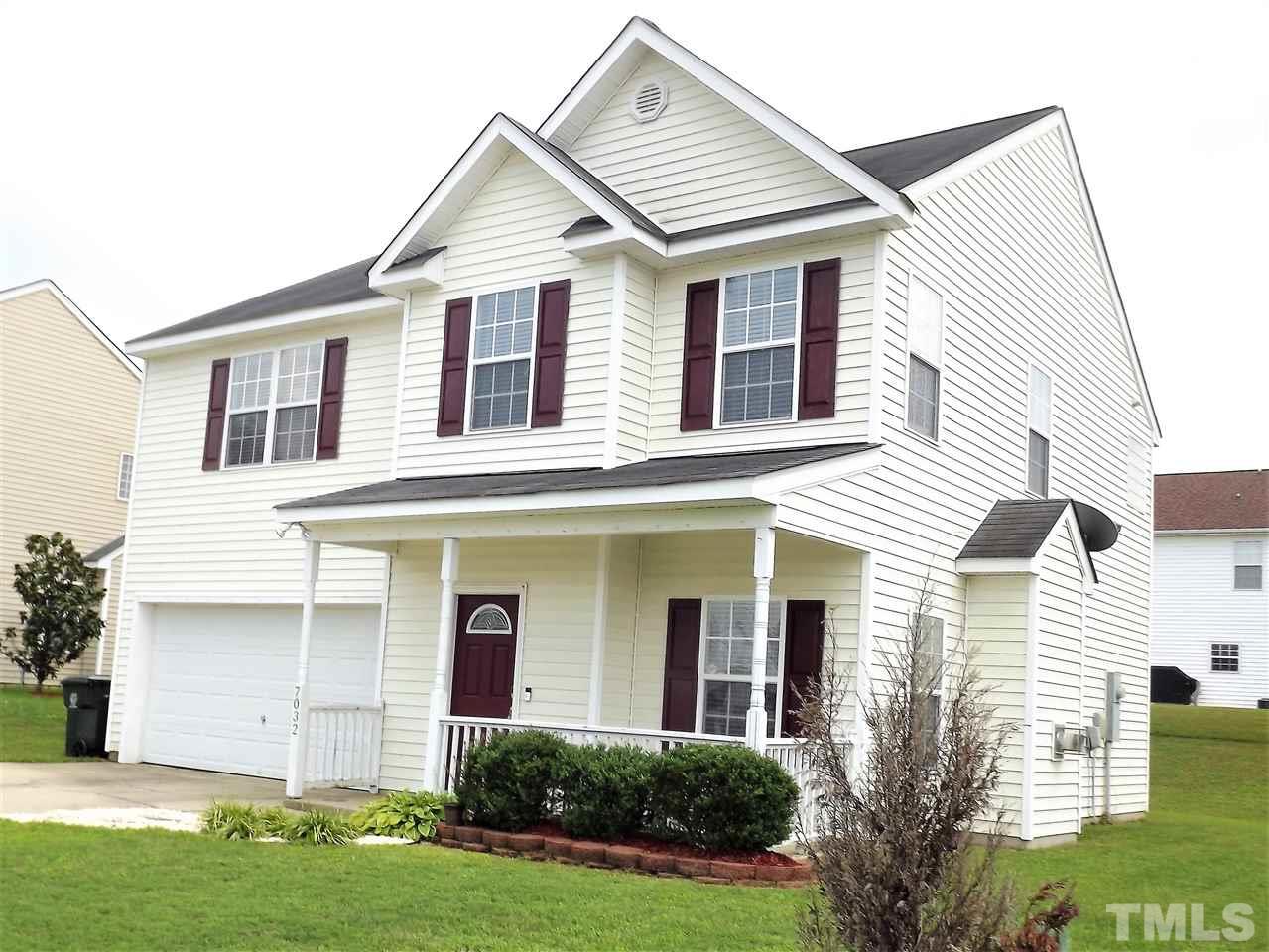 7032 Spanglers Spring Way Raleigh, NC 27610 - Photo 2 of 25 a front view of a house with a yard and garage