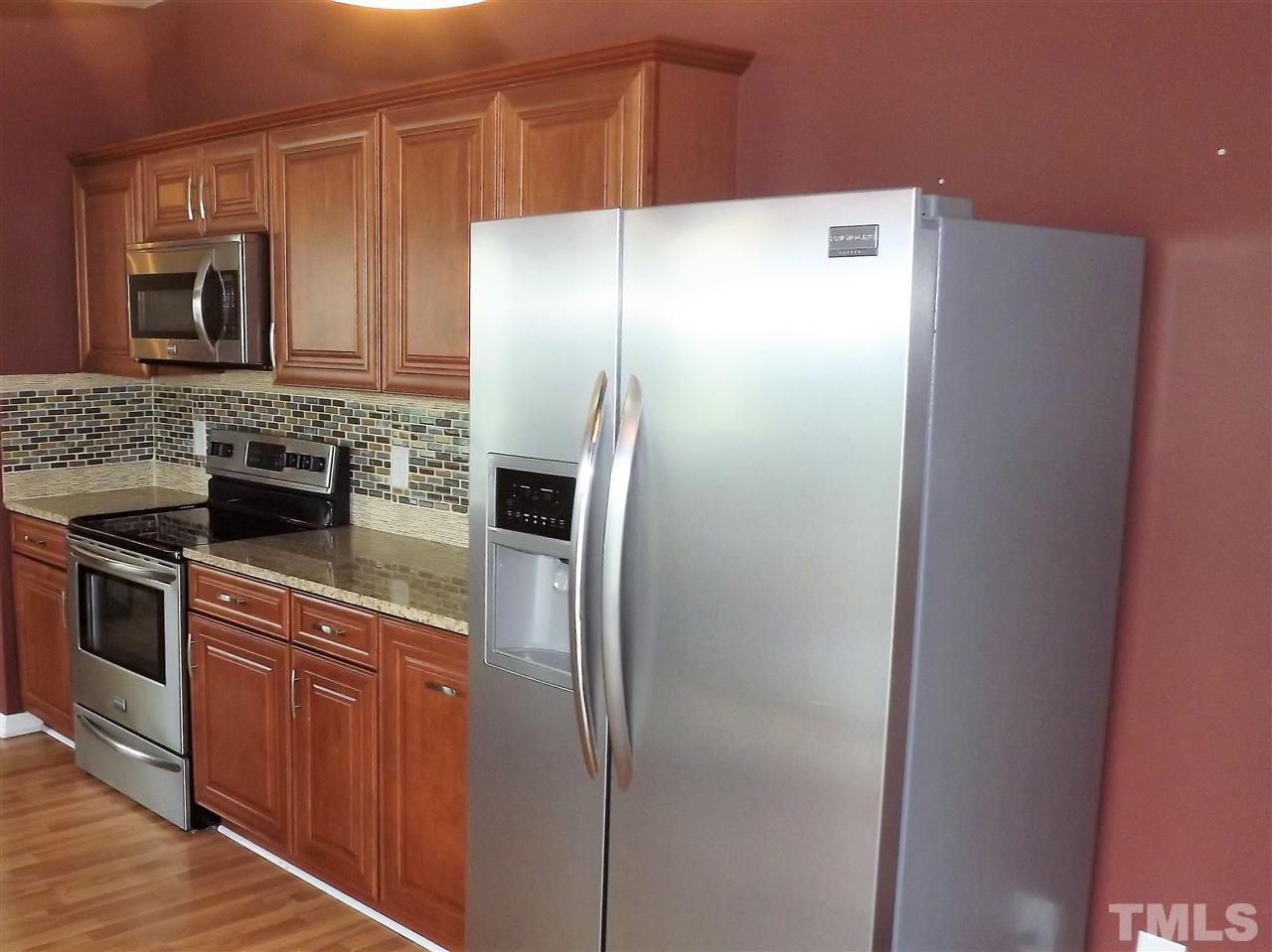 7032 Spanglers Spring Way Raleigh, NC 27610 - Photo 11 of 25 a kitchen with stainless steel appliances granite countertop a refrigerator and a stove top oven