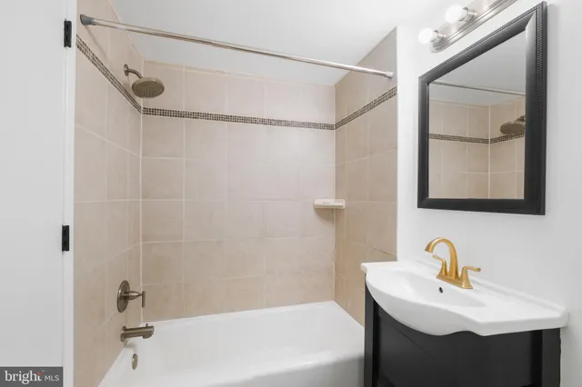 a bathroom with a sink mirror and a bathtub