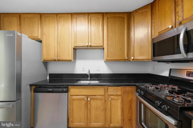 a kitchen with granite countertop cabinets and steel stainless steel appliances
