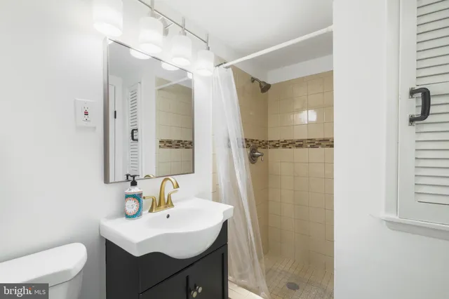 a bathroom with a sink toilet a mirror and shower