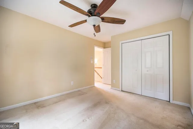 an empty room with a ceiling fan and a window