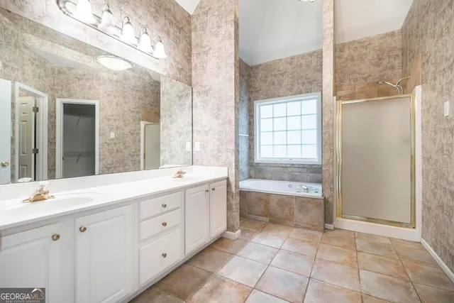 a spacious bathroom with a granite countertop sink a toilet mirror and bathtub