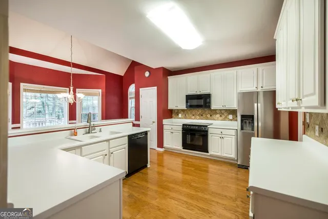 a large kitchen with stainless steel appliances granite countertop a stove and a sink