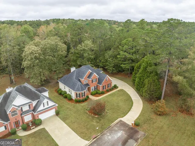 an aerial view of a house with swimming pool and lake view