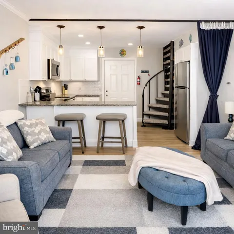 a living room with furniture and a dining table with wooden floor