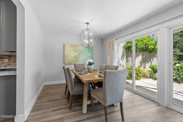 a view of a dining room with furniture a chandelier and wooden floor