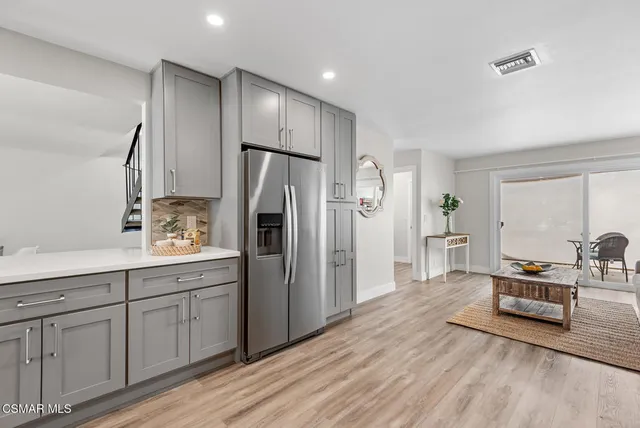 a kitchen with stainless steel appliances a refrigerator and wooden floor