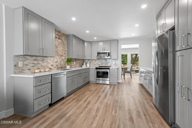 a kitchen with white cabinets and stainless steel appliances