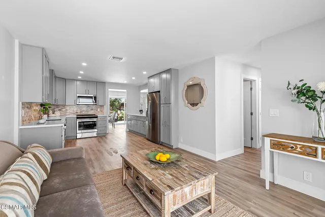 a living room with furniture and kitchen view