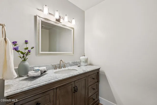 a bathroom with a granite countertop sink and a mirror