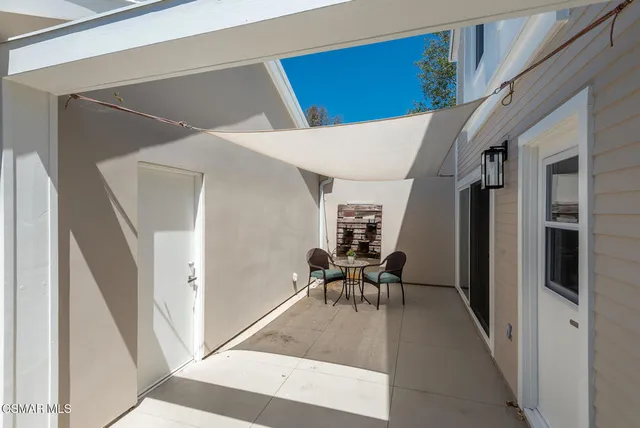 a view of a hallway with chairs and couches with wooden floor