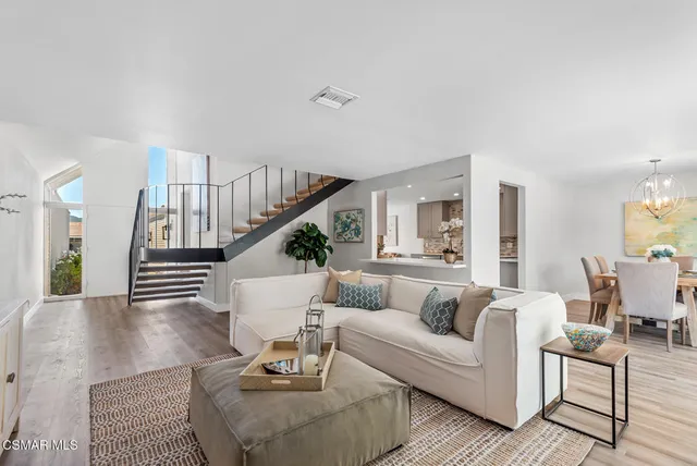 a living room with furniture and a dining table with wooden floor