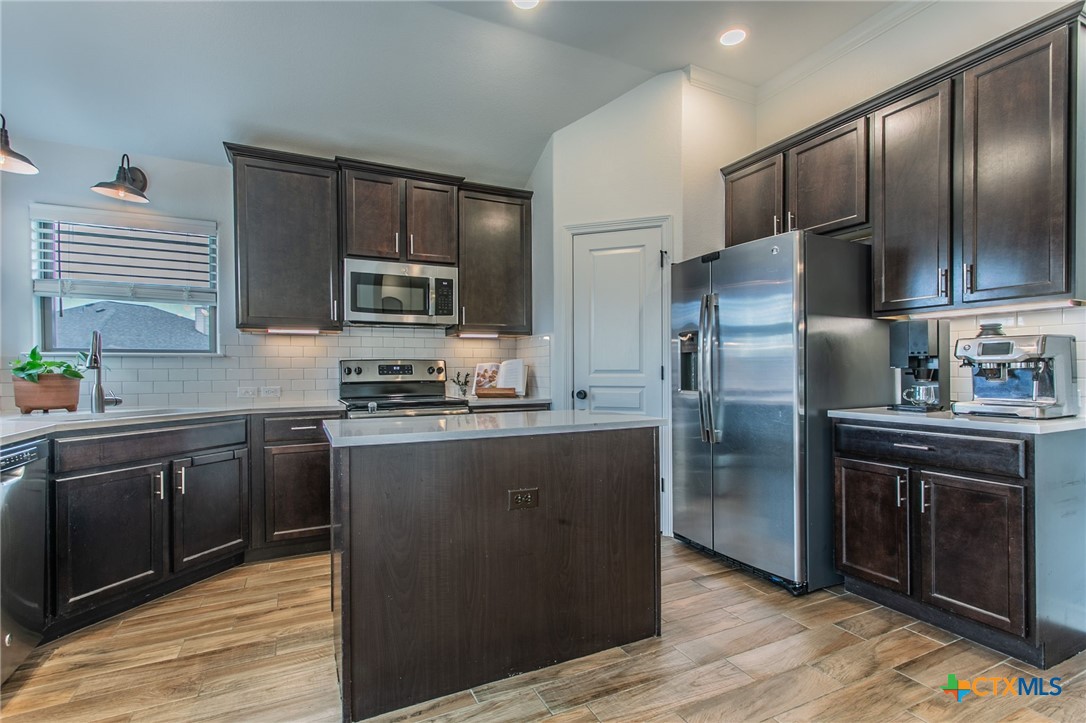 8304 Split Trl Cove Temple, TX 76502 - Photo 6 of 28 a kitchen with granite countertop stainless steel appliances and wooden cabinets