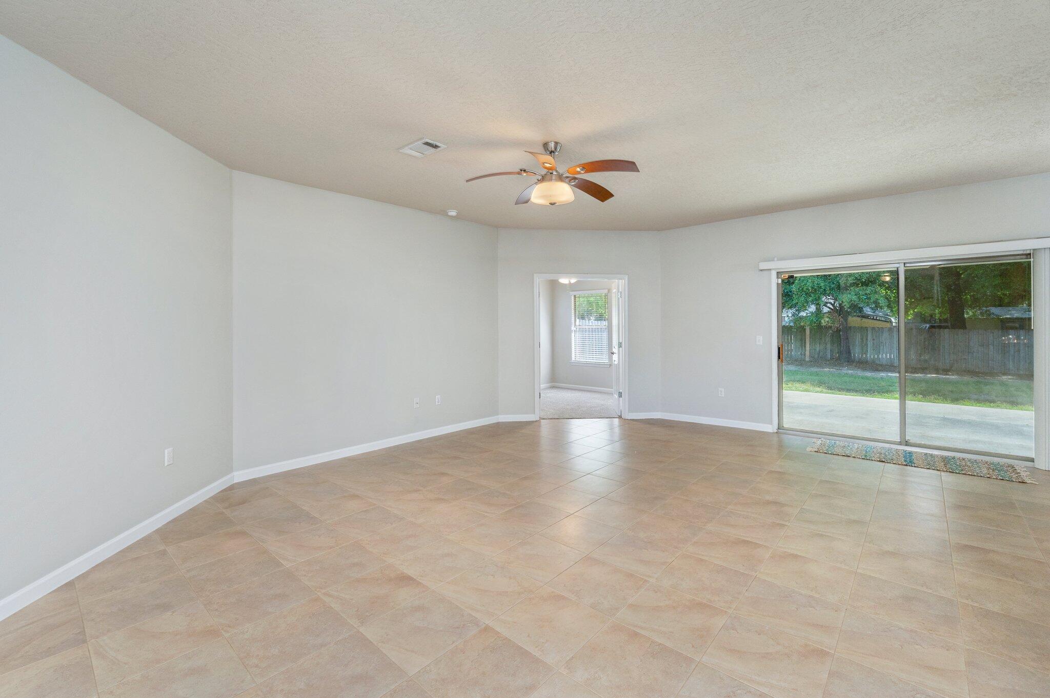 5280 Moore Loop Crestview, FL 32536 - Photo 11 of 54 an empty room with windows and ceiling fan