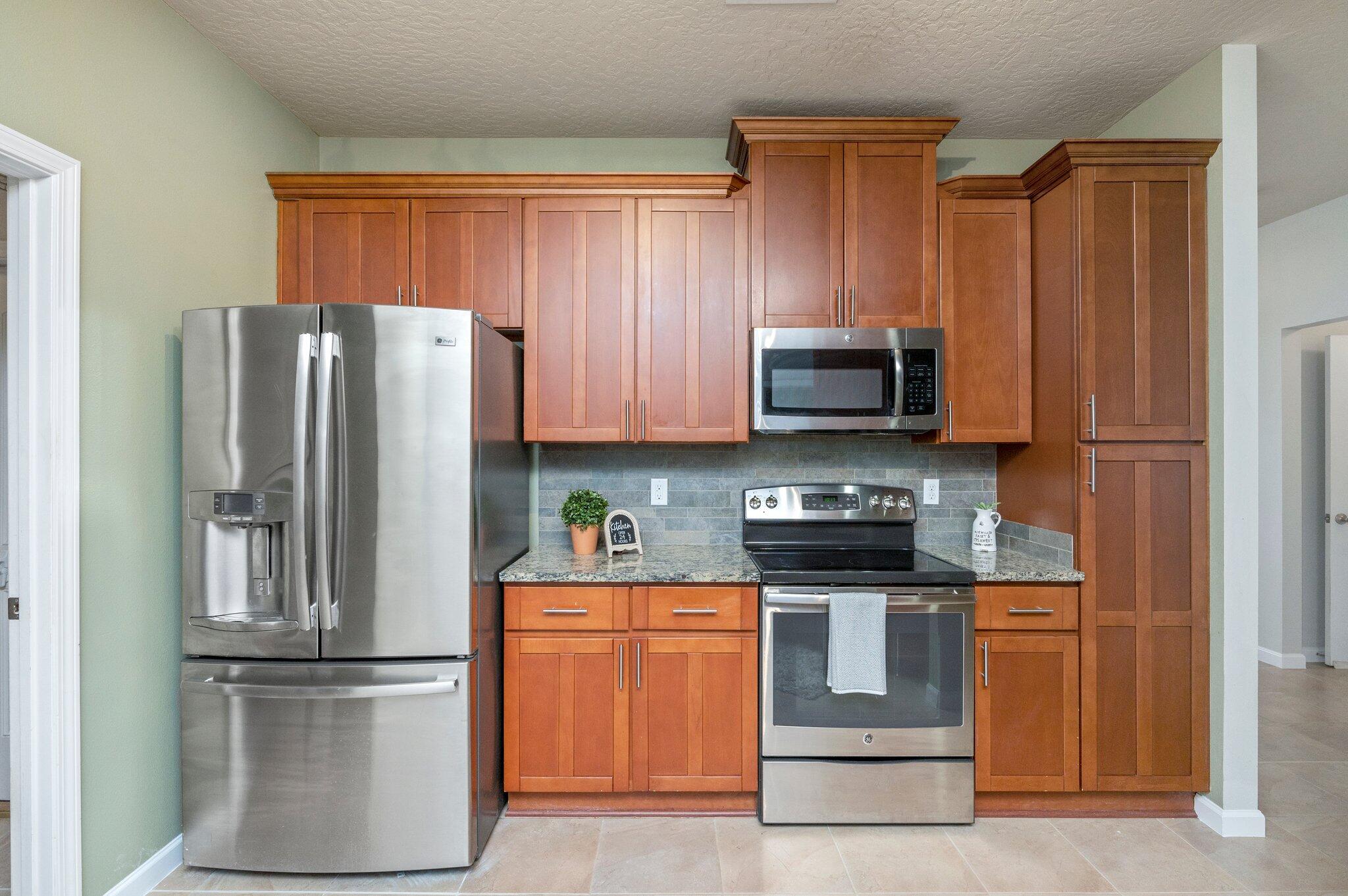 5280 Moore Loop Crestview, FL 32536 - Photo 17 of 54 a kitchen with stainless steel appliances granite countertop a refrigerator stove and microwave